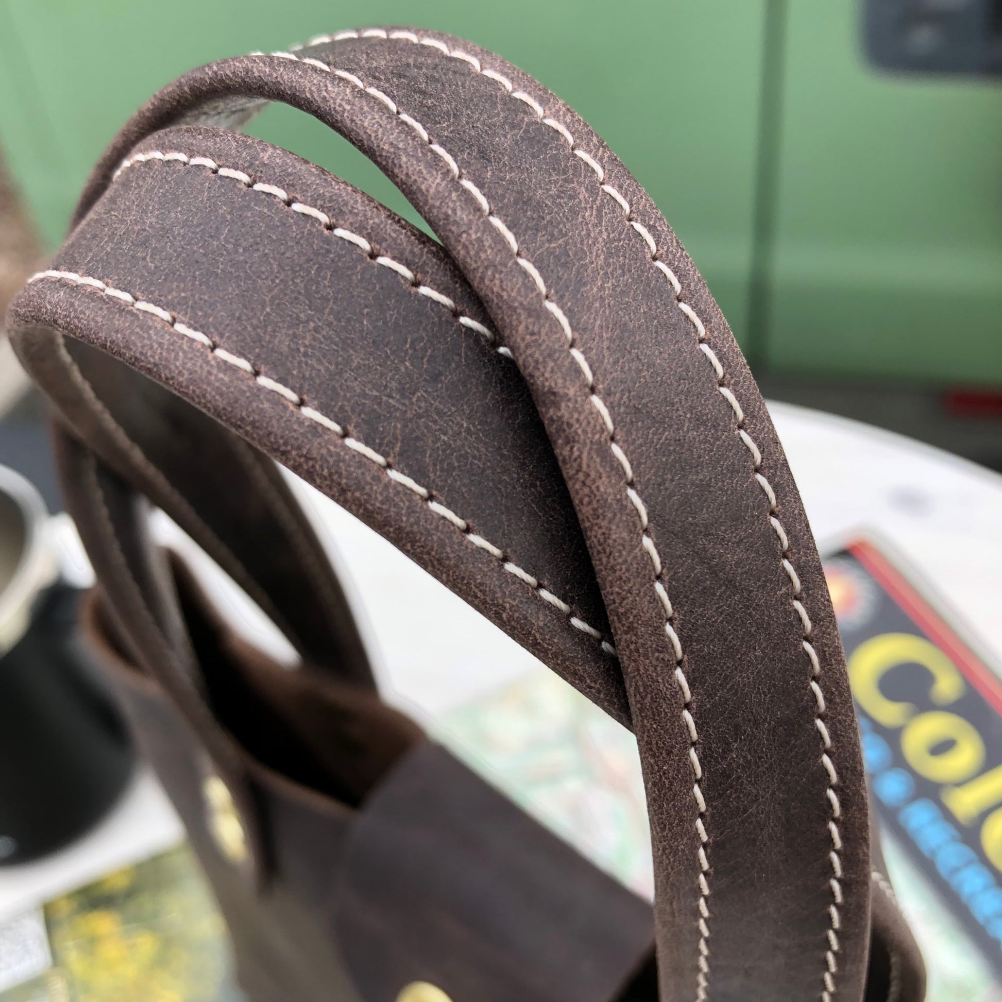 Close up of the edge stitched leather straps on the tiny leather tote bag